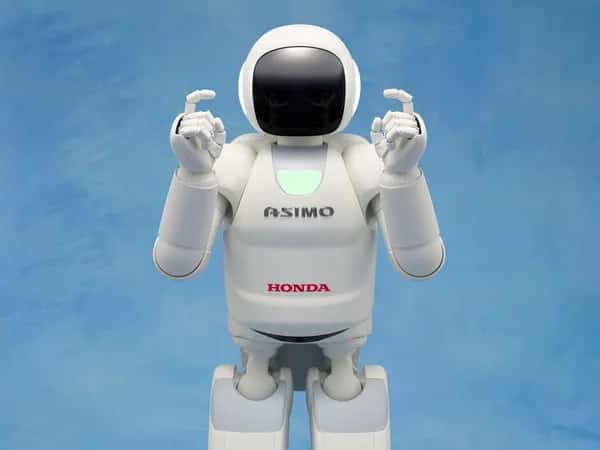 Человекоподобный робот ASIMO поднимает пальцы вверх.