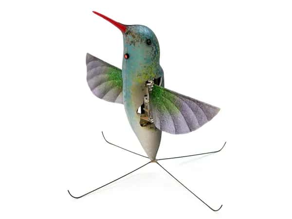 Nano Hummingbird — робот в форме колибри — с крыльями и длинным тонким оранжевым клювом — стоит на четырёхштырьковом основании.