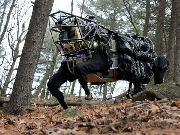 AlphaDog — очень большой чёрный четырёхногий робот в лесу.