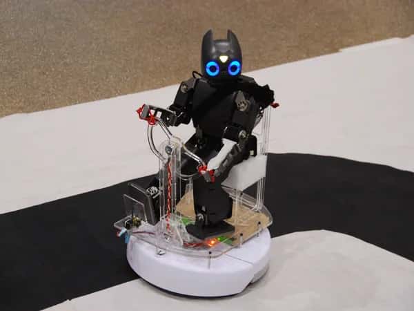 Darwin-OP — маленький робот-гуманоид едет верхом на роботе-пылесосе Roomba.