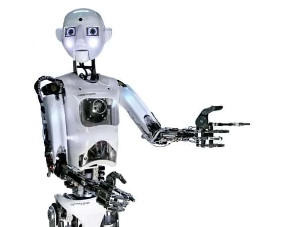 RoboThespian — выразительный гуманоидный робот с круглым ярким лицом, блестящим корпусом с датчиками и двумя руками с чёрными шарнирными пальцами.