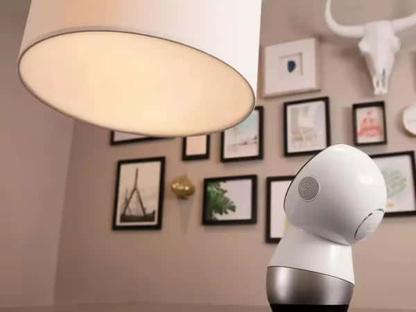 Робот Jibo смотрит вверх на большую лампу.