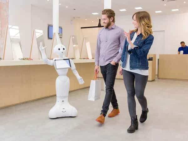 Pepper приветствует клиентов, уходящих из магазина.