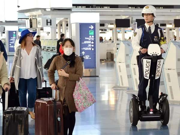 Полицейский на Segway проезжает мимо пассажиров в аэропорту.