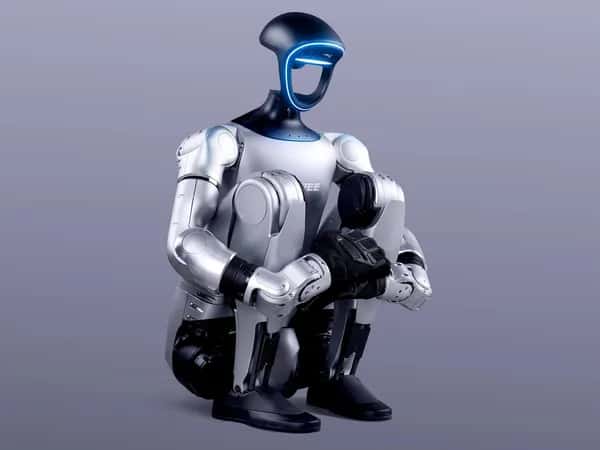 Unitree G1 — двуногий гуманоидный робот G1 от Unitree Robotics приседает до упора — корпус прижат к ногам, руки обхватывают голени.