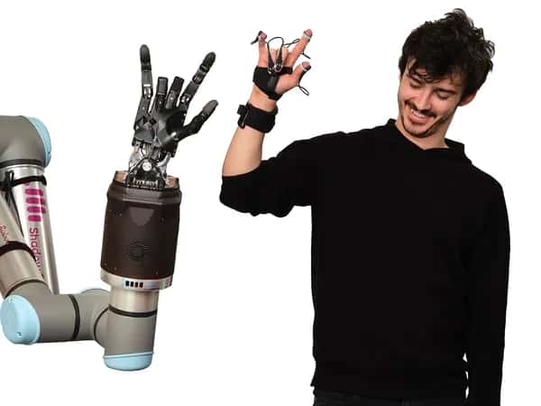 Shadow Hand — роботизированная пятипалая рука на основании выполняет жест. Справа — улыбающийся мужчина повторяет тот же жест, на руке у него специальный фиксатор с датчиками.