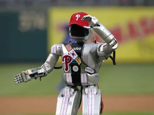 Hubo 2 — робот стоит на бейсбольном поле в кепке Phillies и частях формы.