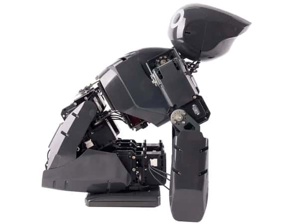 Darwin-OP — чёрный гуманоидный робот согнулся с коленями вперёд, торс, голова и руки откинуты назад.