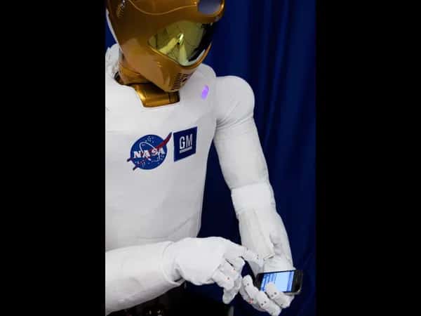 Robonaut 2 — робот держит телефон в одной руке и управляет экраном пальцем другой.