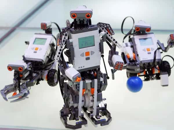 Lego Mindstorms NXT — гуманоидный робот из кубиков Lego с программируемым модулем вместо туловища. Позади него — ещё две конфигурации робота.