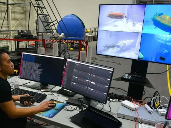 Aquanaut — инженер смотрит на четыре монитора с изображениями и данными от подводного робота.