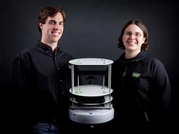 TurtleBot — мужчина и женщина в черных футболках держат многоярусного белого круглого робота.