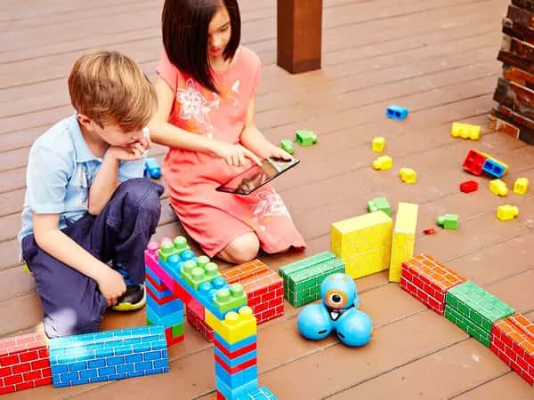 Dash and Dot — двое детей играют с синим роботом, напоминающим три соединённых шара.