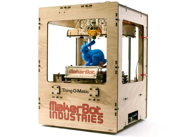 Replicator+ — на простой деревянной платформе MakerBoot Industries стоит синий кролик, напечатанный на 3D-принтере.