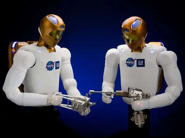 Robonaut 2 — два робота-астронавта держат инструменты.