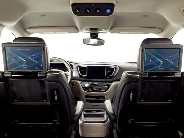 Waymo — вид с заднего сиденья автомобиля: на спинках передних сидений — экраны, отображающие движение машины по сетке дорог.