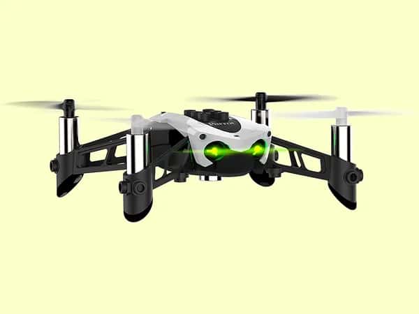 Mambo FPV — белый дрон с светящимися зелёными глазами в полёте на жёлтом фоне.