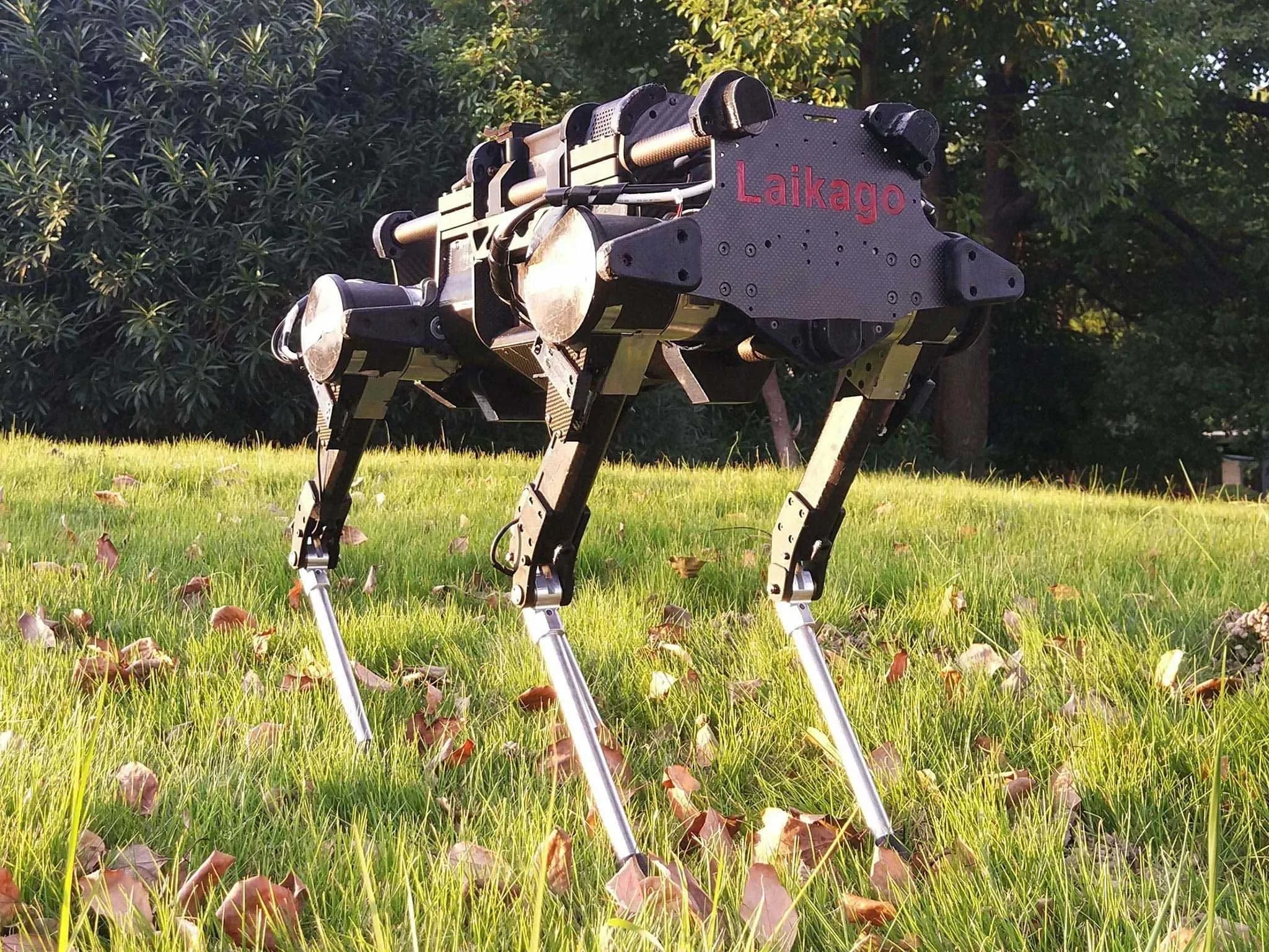 Чёрный четвероногий робот с прямоугольным корпусом с надписью Laikago стоит в траве.